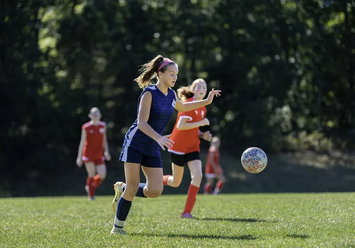 Travel team girl secures soccer ball