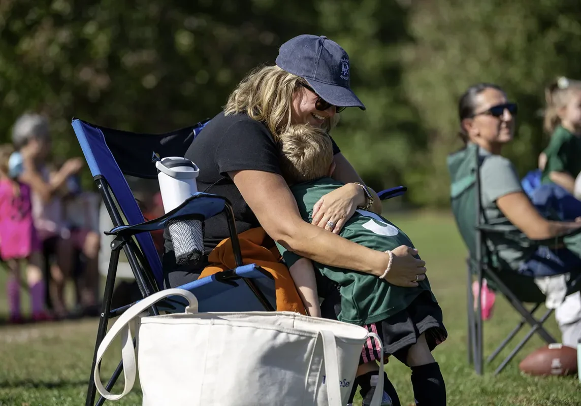 Soccer mom hugging her son